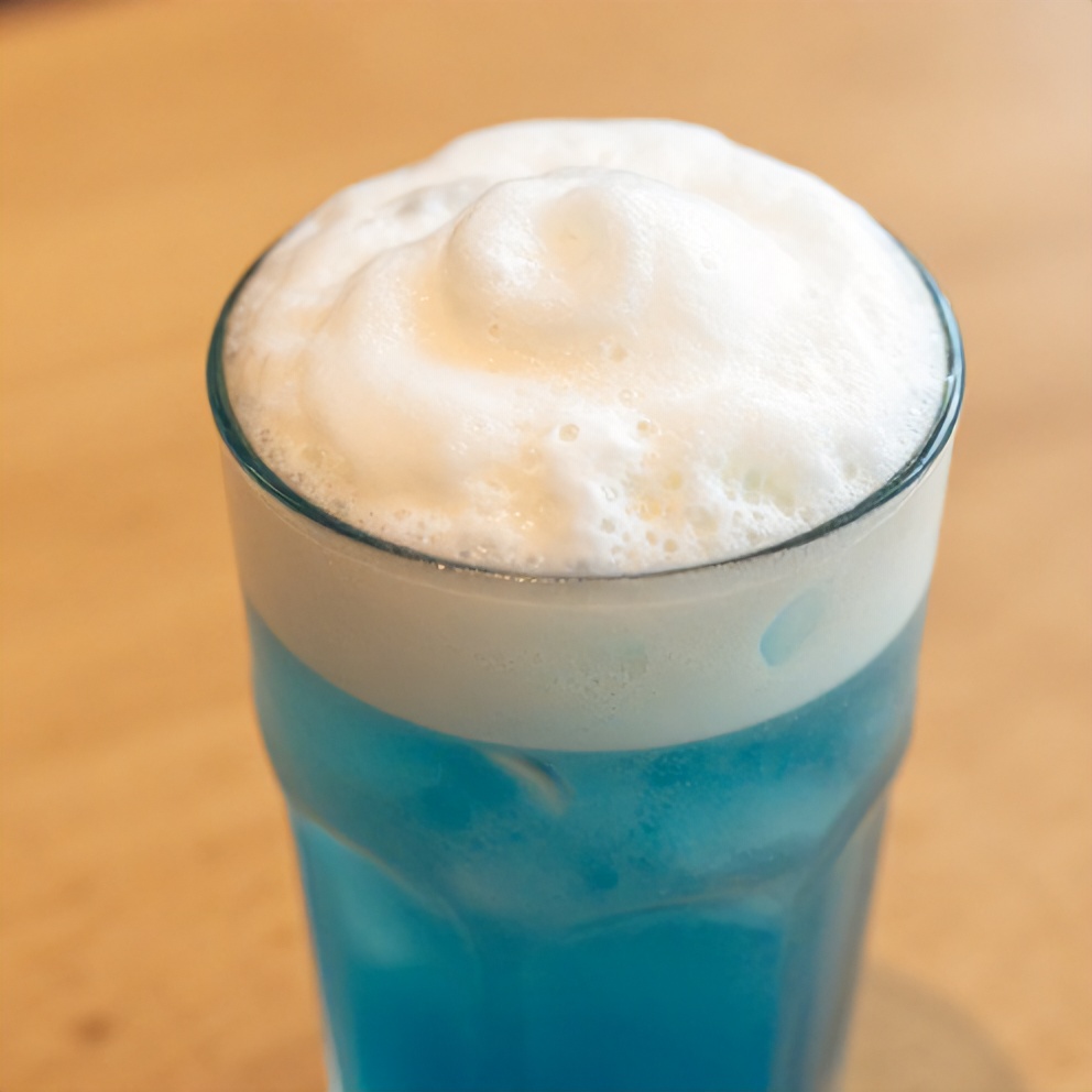 Iced blue tea latte with vanilla cold foam garnished with mint