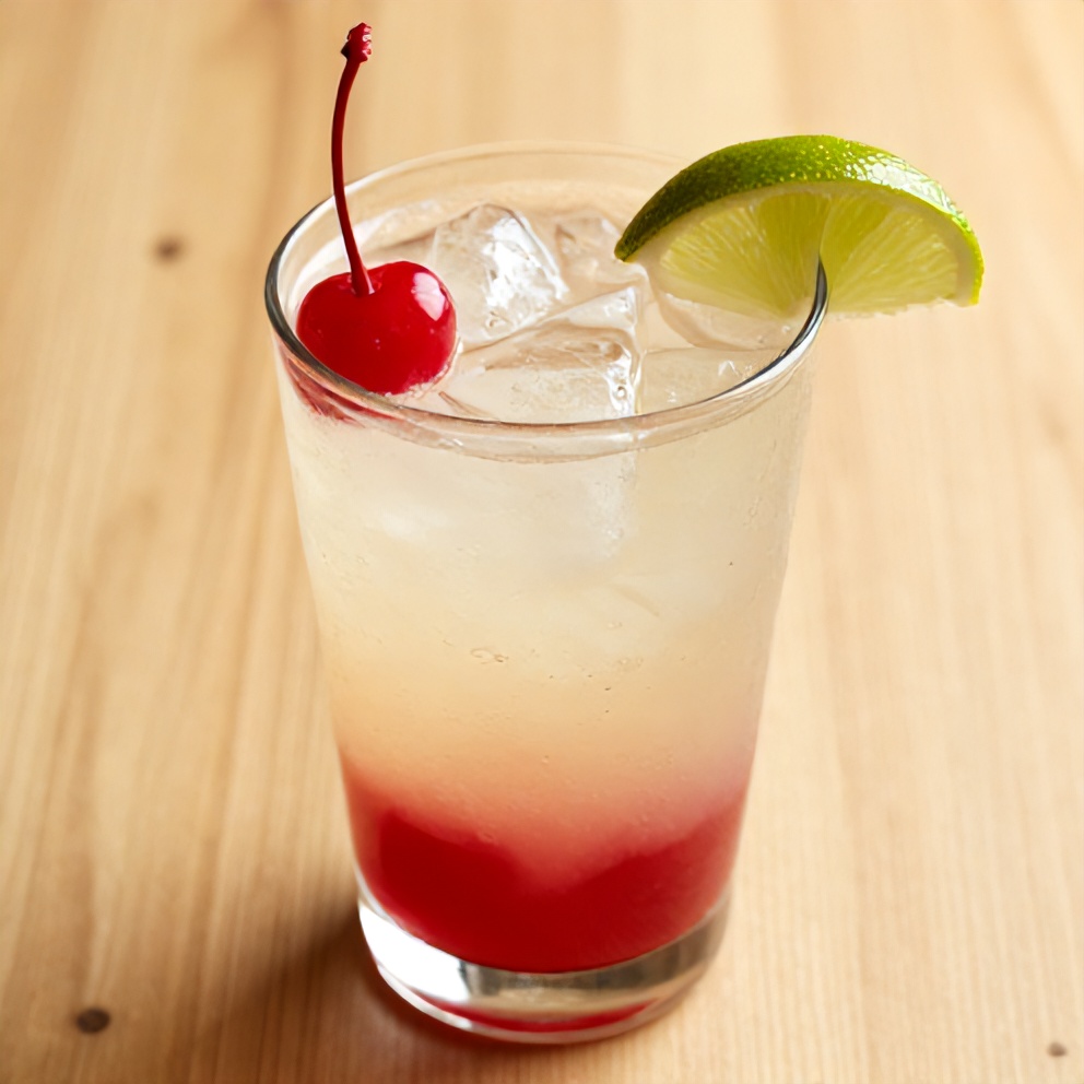A glass of cherry limeade with a cherry and lime garnish